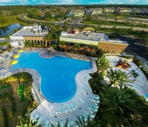 A large swimming pool with a curved design, surrounded by lounge chairs and umbrellas. - 350 Festival Townhome 3 Bedroom by Florida Star (Sarasota)