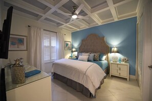 A bedroom with a bed, bedside tables, a ceiling fan, and a window with blinds.