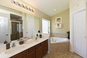 A bathroom with two sinks, a large mirror, and a bathtub. - 4452 Veranda Palms House 4 Bedroom by Florida Star (Kissimmee)