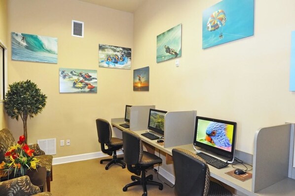 A workspace with cubicles, computers, and artwork on the walls.