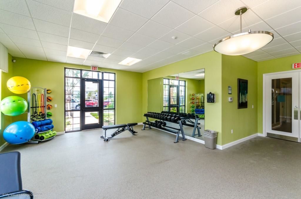 A gym with exercise equipment, a bench, and a mirror on the wall.