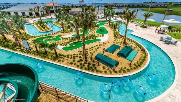 Un espace piscine doté de plusieurs toboggans et d’un parcours de golf.