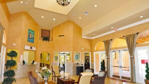 A spacious lobby with a high ceiling, a reception desk, comfortable seating, and large windows. - 601 Bella Vida Condo 4 Bedroom by Florida Star (Kissimmee)