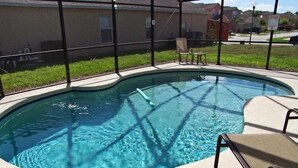 Une piscine à bord incurvé, entourée d’une enceinte en verre.