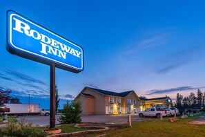 A Rodeway Inn sign with a building in the background.