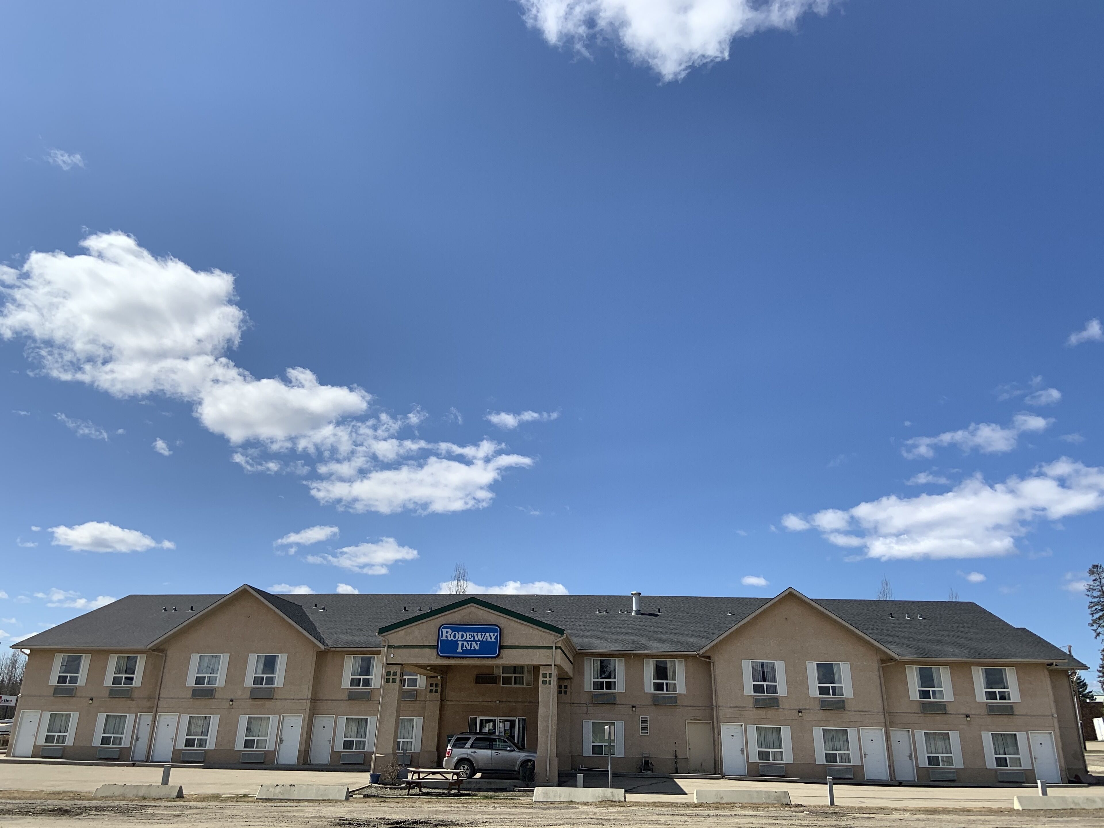 Un hôtel à plusieurs étages, avec une enseigne indiquant « Rodeway Inn » à l’entrée.