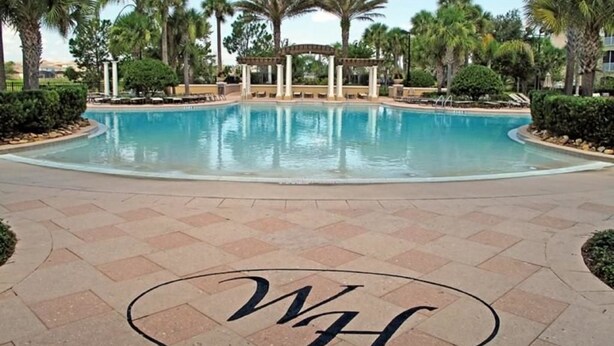 A swimming pool with a pergola and palm trees in the background. - 7767 The Windsor House 6 Bedroom by Florida Star (Kissimmee)