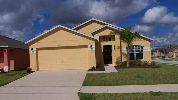 A single-story house with a garage, a front yard, and a clear sky.