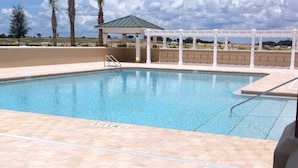 A swimming pool with a white pergola and a covered area in the background. - Rabbit Run Path Home 3 Bedroom by The VIR Group (Wildwood)
