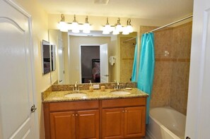 A bathroom with a double sink vanity, a large mirror, and a shower area with a curtain. - 8939 Paraside Palms Townhome 4 Bedroom by Florida Star (Kissimmee)