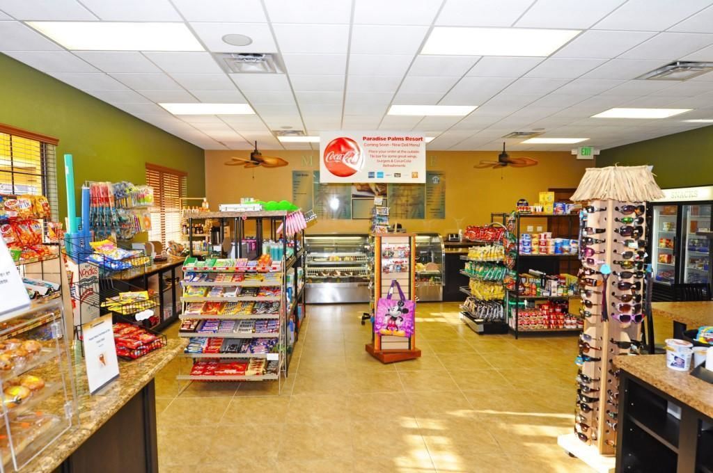 A brightly lit convenience store with shelves stocked with snacks, beverages, and other items.
