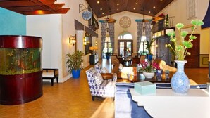 A spacious lobby with a large aquarium, comfortable seating, and a variety of plants. - 8981 Paradise Palms Townhome 5 Bedroom by Florida Star (Kissimmee)