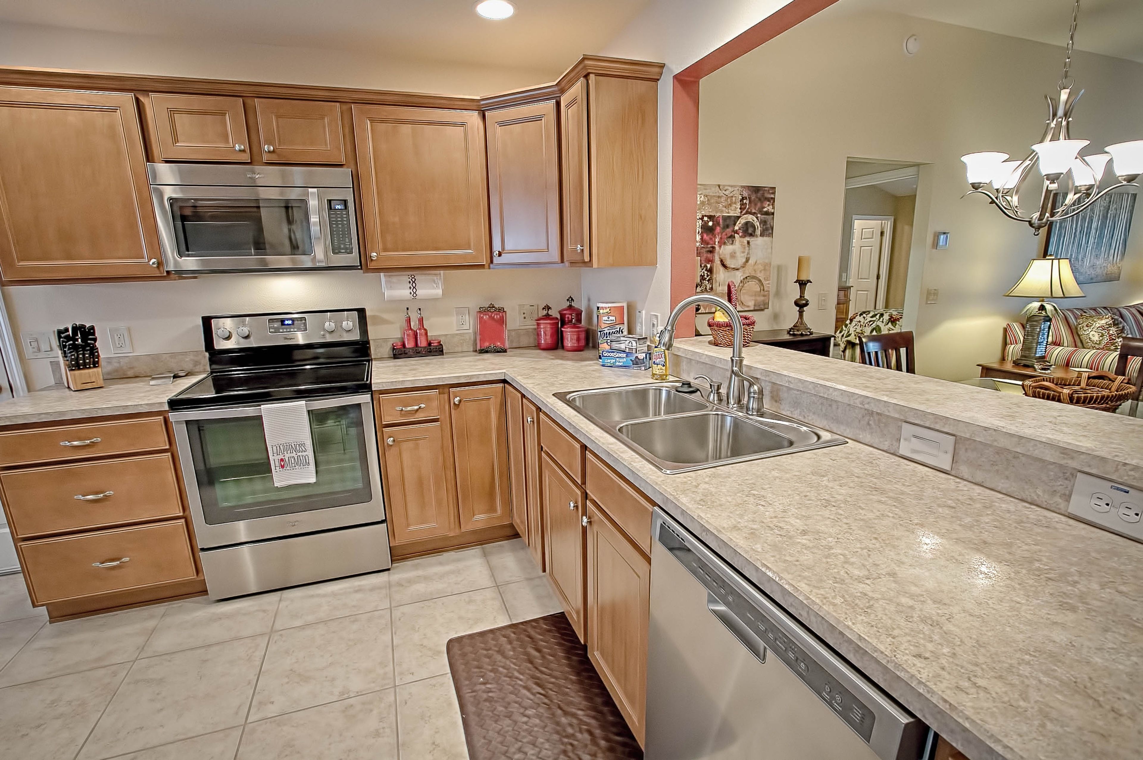 A modern kitchen with wooden cabinets, stainless steel appliances, and a granite countertop.