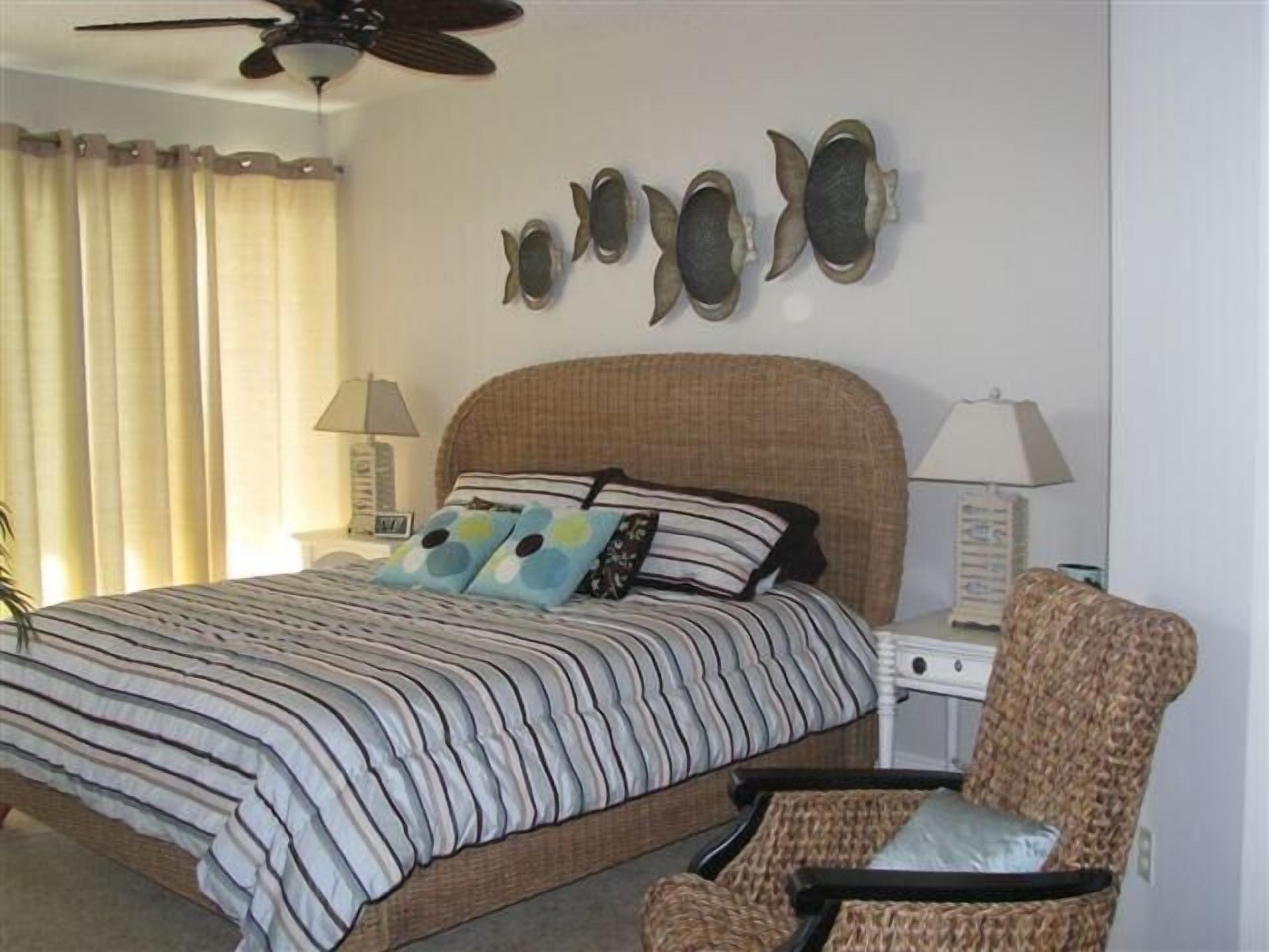 A bedroom with a bed, a chair, and wall art.