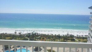 A beach view from a balcony with a pool, palm trees, and a clear sky. - St Croix at Silver Shells 3 Bedroom Apartment by BnD (Destin)