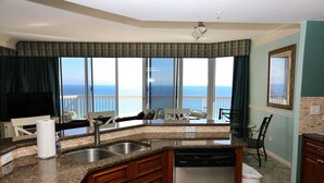 A kitchen with granite countertops, a dishwasher, and a view of the ocean. - St Croix at Silver Shells 3 Bedroom Apartment by BnD (Destin)