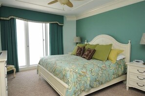 Une chambre à coucher avec un lit, une table de chevet, une lampe et un ventilateur de plafond.
