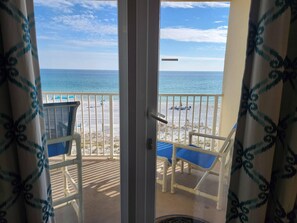 Ein Balkon mit Blick auf Strand und Meer.