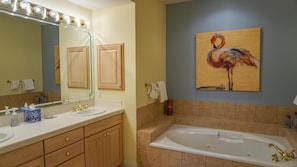 Une salle de bain équipée d’un lavabo, d’un miroir, d’un meuble-lavabo et d’une baignoire.