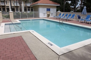Une piscine équipée de chaises longues et d’un poste de surveillance pour les sauveteurs.