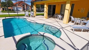 A swimming pool with a sunken section, surrounded by lounge chairs and a covered patio area. - 101 Aviana House 6 Bedroom by Florida Star (Davenport)