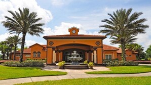A large building with a central fountain, surrounded by well-maintained lawns and palm trees. - 101 Aviana House 6 Bedroom by Florida Star (Davenport)