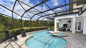 A swimming pool with a covered patio area, lounge chairs, and a barbecue setup.