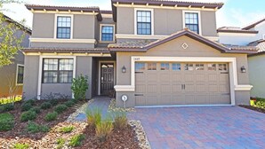 A two-story house with a garage, a front door, and a driveway.
