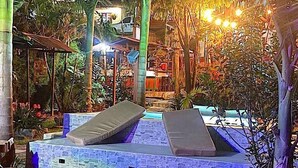 Un área de piscina con sillones de descanso y una pared de piedra.