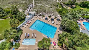 A resort with a large swimming pool, sun loungers, and a beach area. - Carolina Dunes 304 2 Bedroom Condo by Luxury (Myrtle Beach)