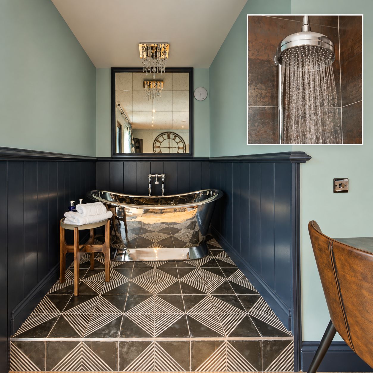 A bathroom with a freestanding bathtub, a wooden stool, a mirror, and a wall-mounted clock.