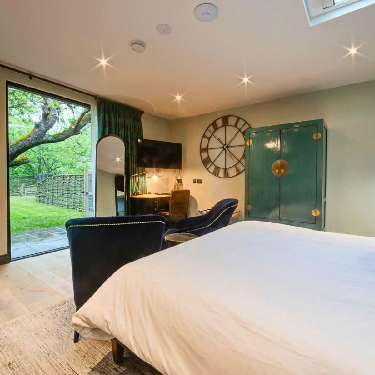 Une chambre à coucher comprenant un lit, un bureau, une chaise, une horloge et une armoire.