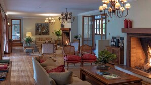 Ein gemütliches Wohnzimmer mit Kamin, Holzmöbeln und einer Chandelier.