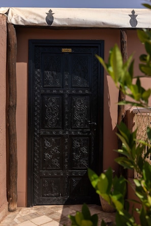 A black door with intricate patterns and a sign above it. - Les Sources Berbères Riad & Spa (Marrakech)