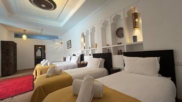 A hotel room with two beds, a red carpet, a decorative wall, and a ceiling light fixture.