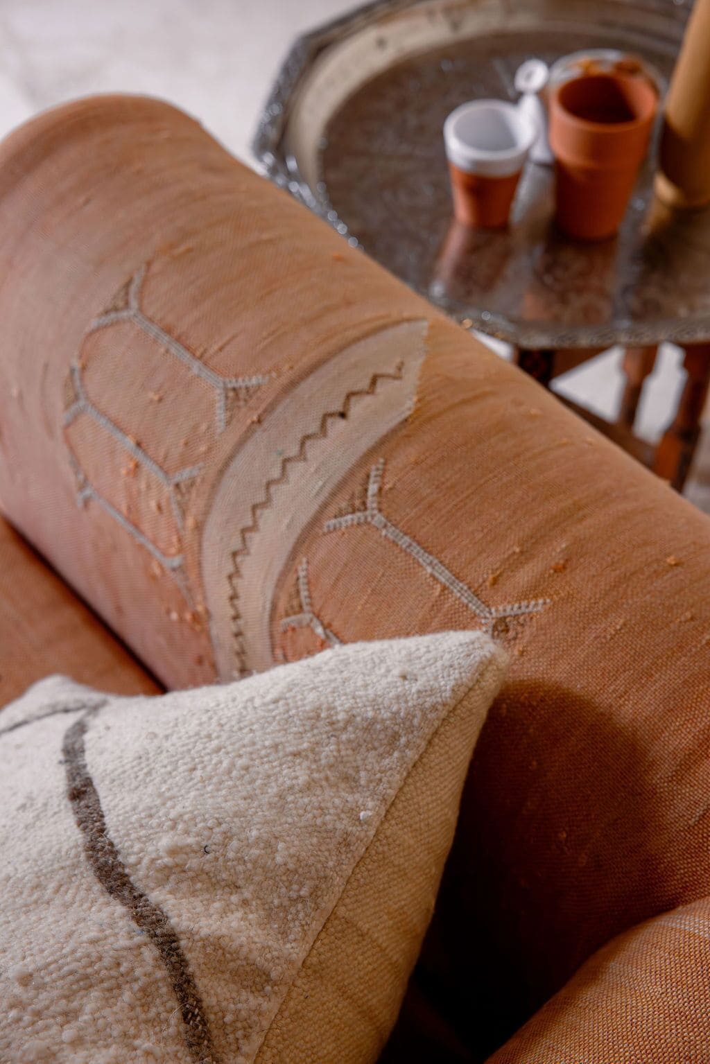 Primer plano de una tela con textura y un diseño geométrico, posiblemente parte de la tapicería de un sofá o sillón.