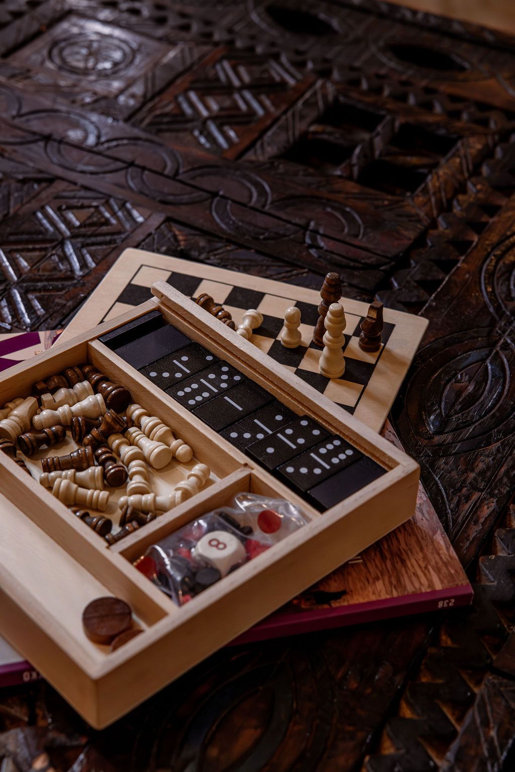 Un juego de ajedrez de madera con piezas y tablero sobre una superficie estampada.