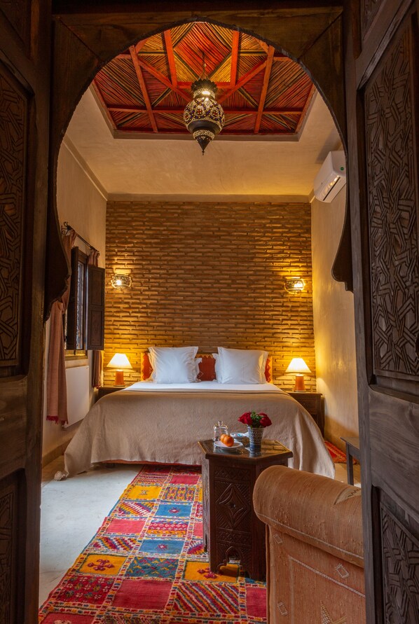 A traditional room with a bed, a patterned rug, and a wooden ceiling. - Les Sources Berbères Riad & Spa (Marrakech)