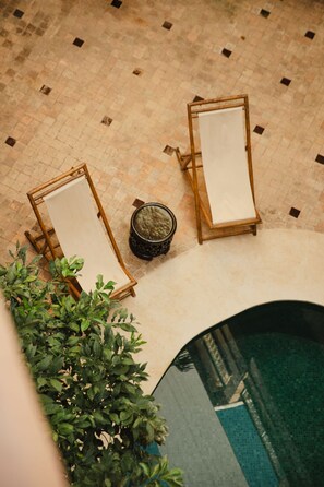 A rooftop pool area with two lounge chairs and a potted plant. - Les Sources Berbères Riad & Spa (Marrakech)