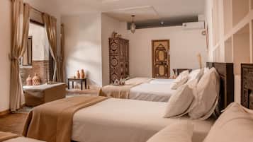 A hotel room with two beds, a large mirror, a chest of drawers, and a decorative door.