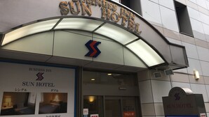 The exterior of the Sun Hotel with a prominent 'BUSINESS INN' sign and a large logo. - Business Inn SUNHOTEL (Machida)