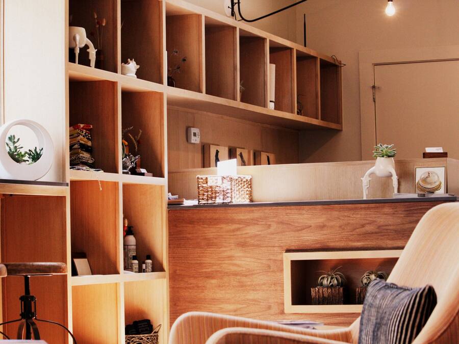 A cozy room with wooden shelving, a comfortable chair, and a desk area.
