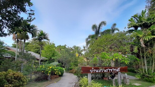 A pathway leading to a building with a sign in a foreign language. - Bann Suan Rachawadee B&B (Sisaket)