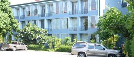 Un hotel con fachada azul, varios balcones y un cartel.