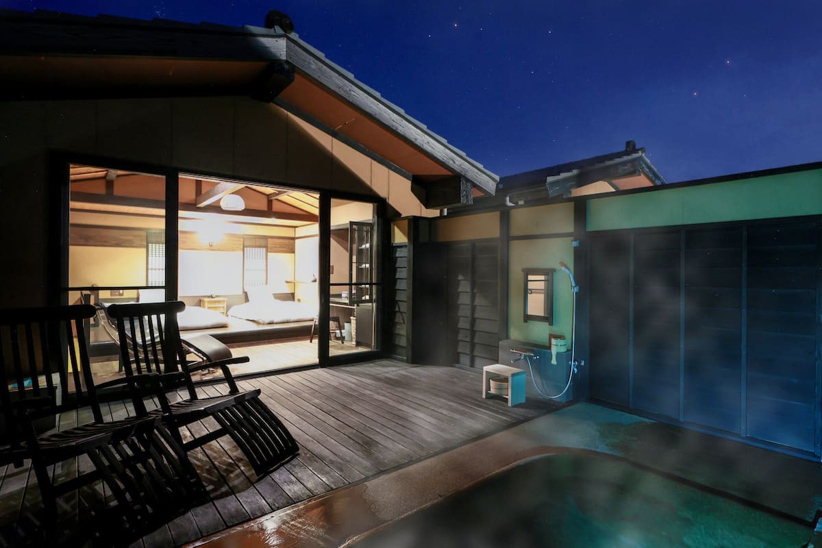 A modern hotel room with a large sliding glass door leading to a balcony.