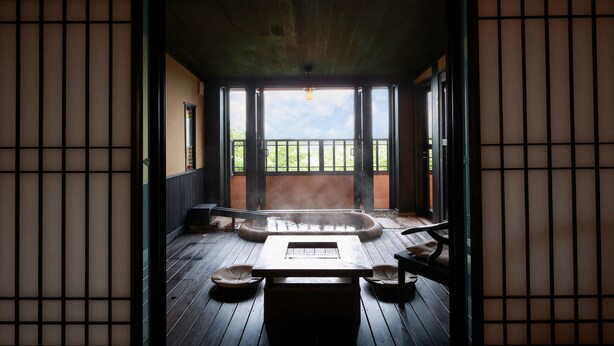 Un onsen japonés tradicional con suelo de madera, un baño de aguas termales y esteras de tatami.