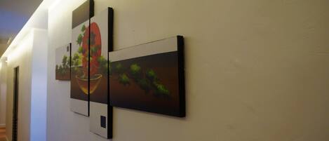 A hallway with two framed artworks on the wall.