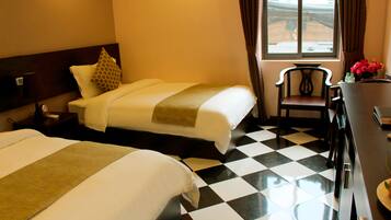 Deluxe Triple Room | Minibar, in-room safe, desk, blackout drapes