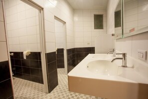 A bathroom with a white sink, black and white tiled walls, and a mirror above the sink.