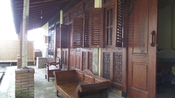 A traditional wooden structure with a bench and a door. - Villa Adas (Ngadisari)
